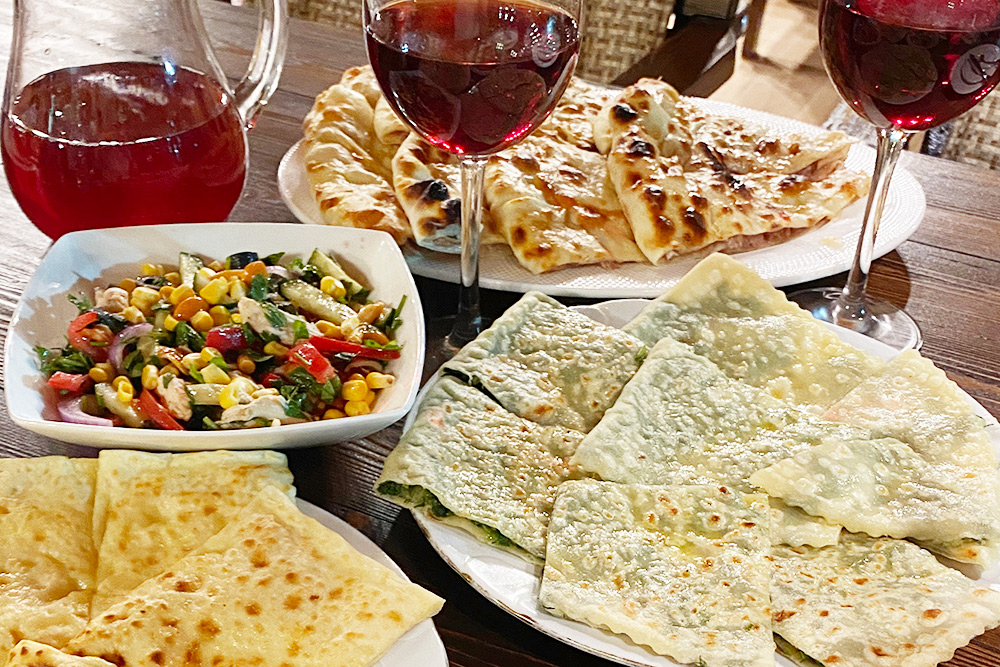Три вида чуду — с мясом, зеленью и сыром, греческий салат, фирменный салат «Крепость», компот в графине, вино в бокалах. За все мы заплатили 1730 <span class=ruble>Р</span>