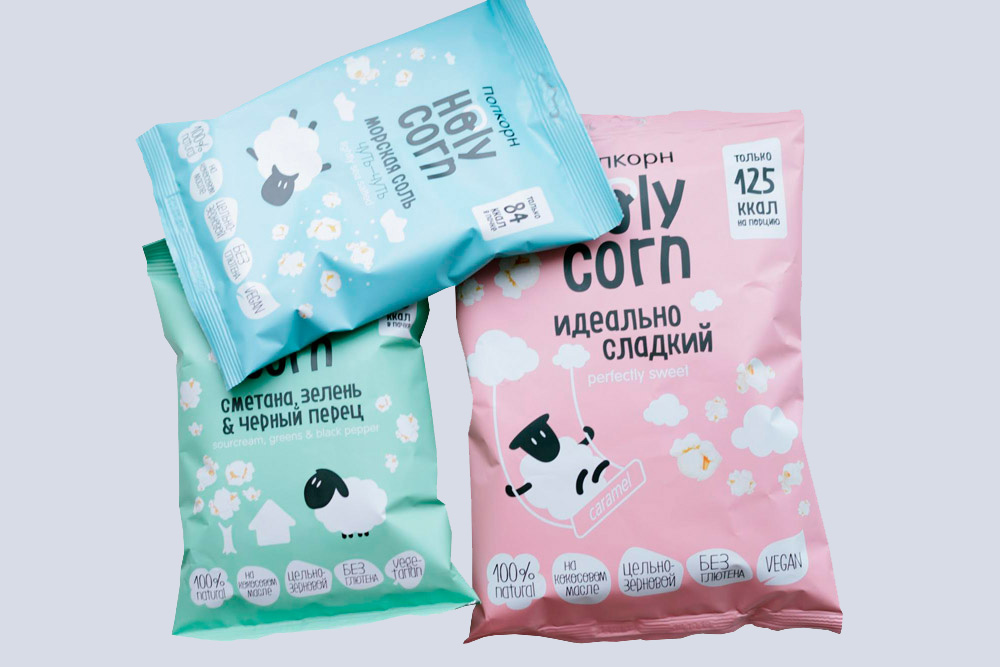 Пачки с тремя разными вкусами продукта. В каждой — 84—125 ккал. Если сравнить «Холи Корн» с попкорном, которым обычно хрустят в кинотеатре, последний покажется пересоленным и суперсладким