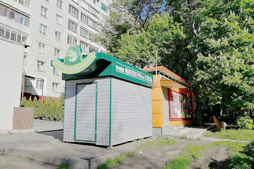 Ларек по сбору макулатуры и стекла. Женщина, принимающая мусор, по совместительству работает в соседнем ларьке «Овощи и фрукты»