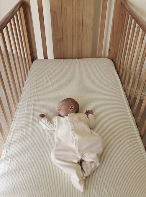 Ребенок спит в одежде, без&nbsp;одеяла и без&nbsp;пеленки. Фото: Glandwr / iStock