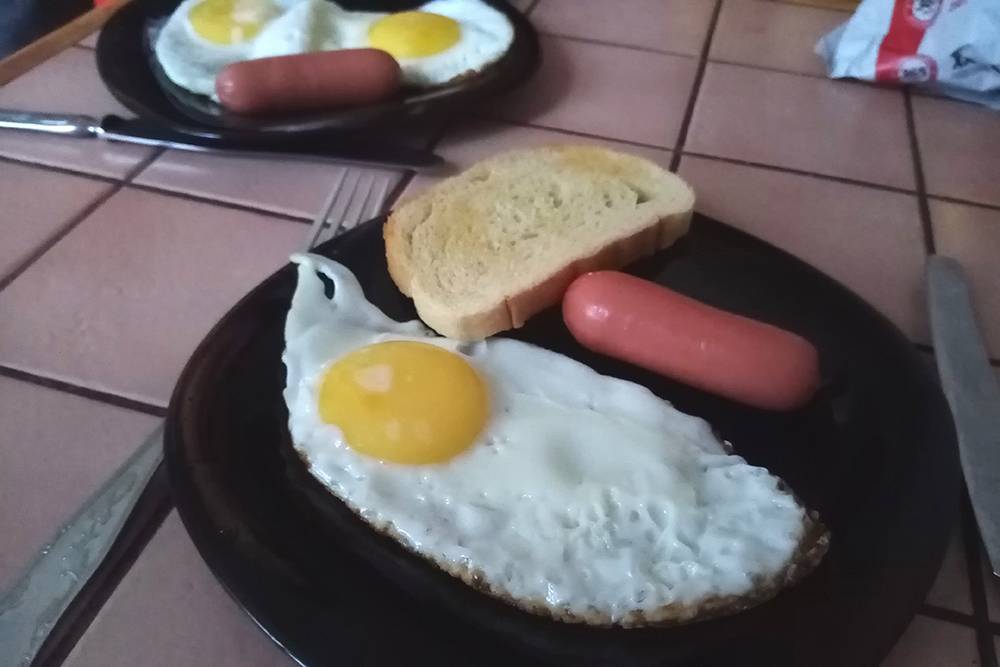 На завтрак жарю нам с мужем яйца — себе одно, мужу два. Грею в микроволновке сосиски, в тостере жарю батон