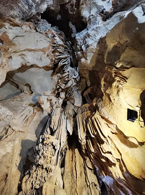 Сталактиты и сталагмиты в пещере подсвечиваются разными цветами — выглядит красиво