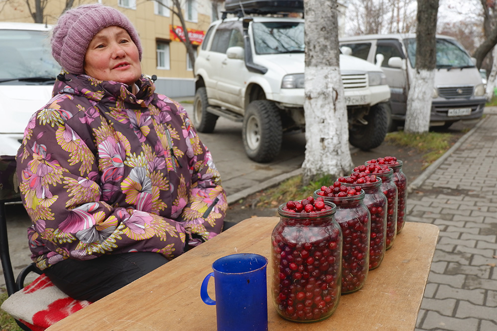 Корсаков. Бабушка продает клюкву, собранную «на болоте среди медведей», по 500 рублей за литр