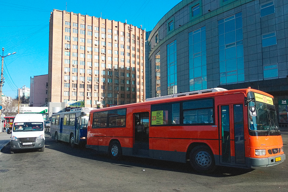 Справа — корейский автобус марки «Дэу», олицетворение общественного транспорта Владивостока в девяностых и начале нулевых. Сейчас «корейцев» почти вытеснили русские «газели» — пошлины на ввоз авто подняли и ввозить подержанные автобусы стало невыгодно