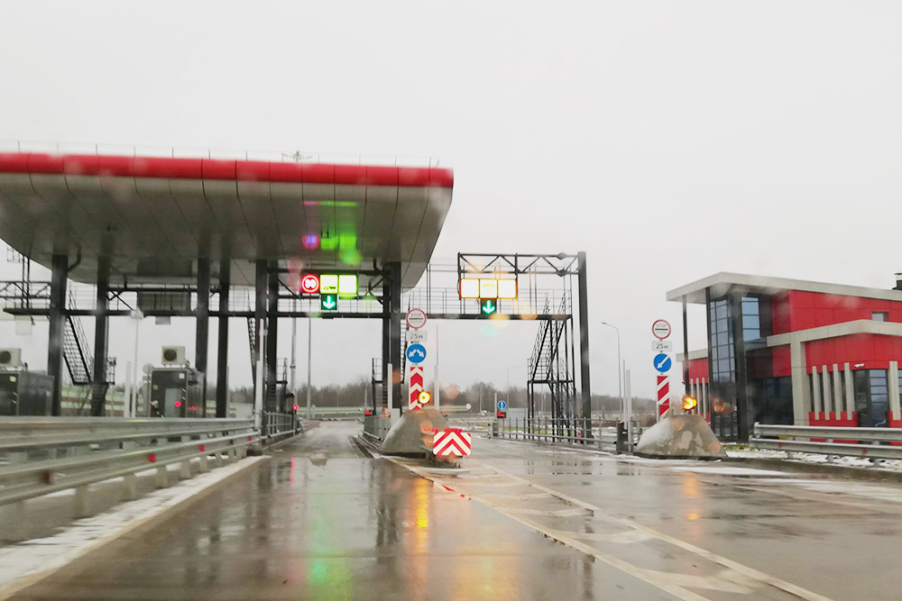 Так выглядит пункт оплаты при въезде на М11 со стороны Великого Новгорода. Правая полоса — для оплаты наличными или картой, там нужно полностью остановиться. Левая полоса — для проезда по транспондеру. Там не надо останавливаться, но нужно проезжать ее со скоростью не больше 30 км/ч, если шлагбаум откроется