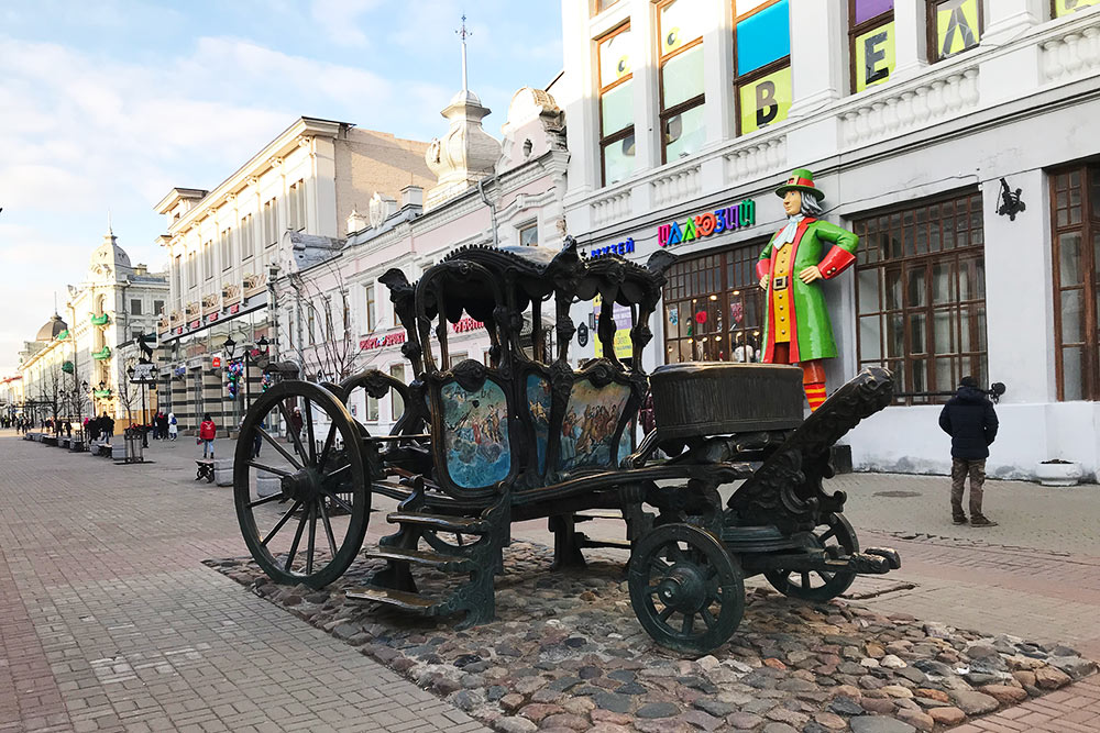 В памятнике карете Екатерины II туристы фотографируются и трогают его на счастье