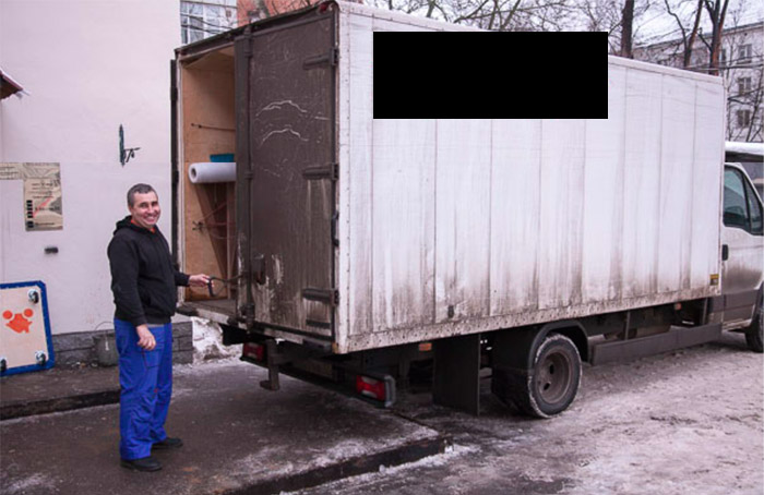 А вот нормальное фото. Водитель профессиональной мувинговой компании на фоне мебельного фургона с брендированным кузовом. Не у всех грузовых компаний будут фирменные тенты на кузовах, но если компания хоть как-то беспокоится о привлечении клиентов, то у них они будут