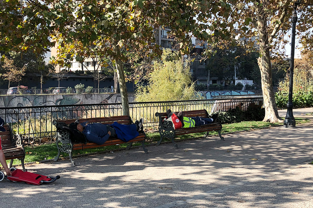 В центре Сантьяго на лавочках спят бездомные