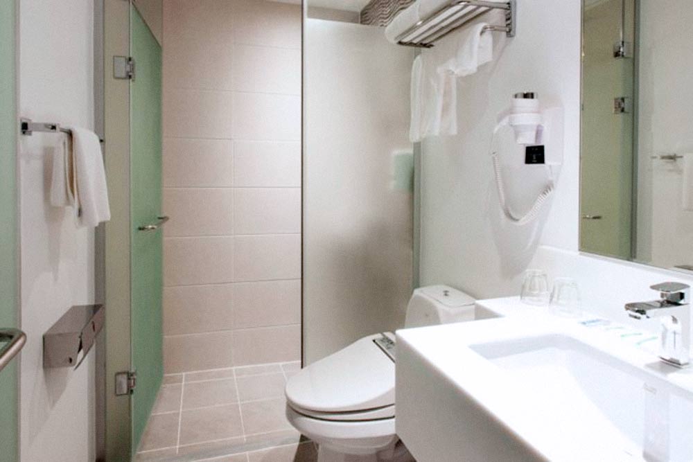 Ванная комната в номере отеля Holiday Inn Express Seoul Euljiro. Там стоит «умный унитаз» с кучей кнопок и пояснениями на корейском языке. Опробовать все его функции мы так и не решились