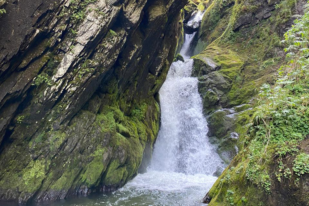 Это водопад Эстюбе. На фото не видно, но ниже находится необычное деревянное сооружение — местная ГЭС