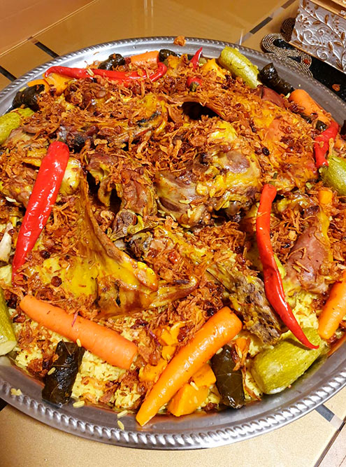 Основное блюдо — рис и мясо — часто подают на больших плоских подносах, чтобы хватило на всю семью