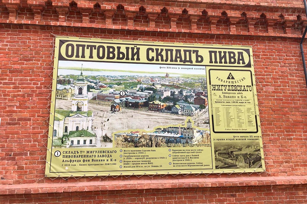 На стене вывеска с историей здания